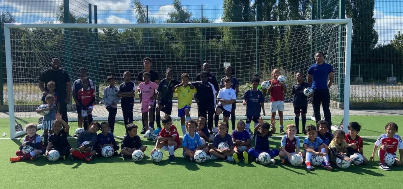 Large diverse community group of children aged 3-13 participating in Soccer Inclusion football training in Birmingham